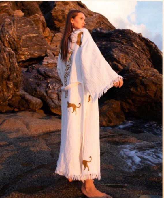Woman in a white tiger robe with animal designs standing on rocky terrain.Turkish cotton kimono robe