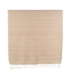 A lightweight Turkish towel with ethnic patterns on a beach at sunset. This super soft, sand-free towel features intricate woven details and fringed edges, held up against a golden ocean backdrop.